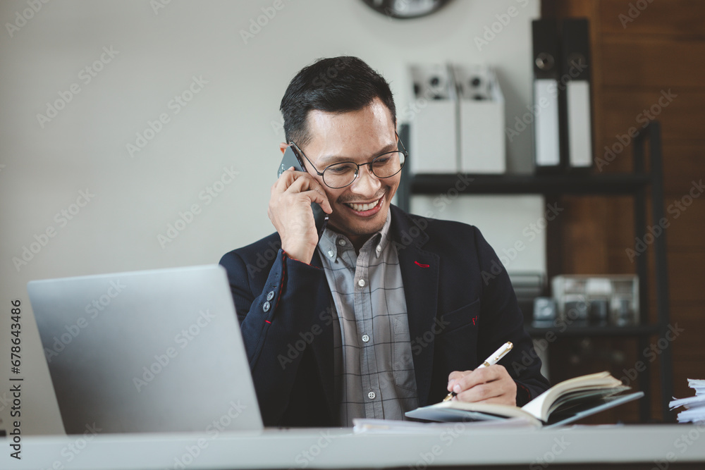 Businessman is working in the office and talking on the phone with a partner, Entrepreneurs use smartphones to find information in order to present it, Working in a private office at a company. Businessman is working in the office and talking on the phone with a partner, Entrepreneurs use smartphones to find information in order to present it, Working in a private office at a company.