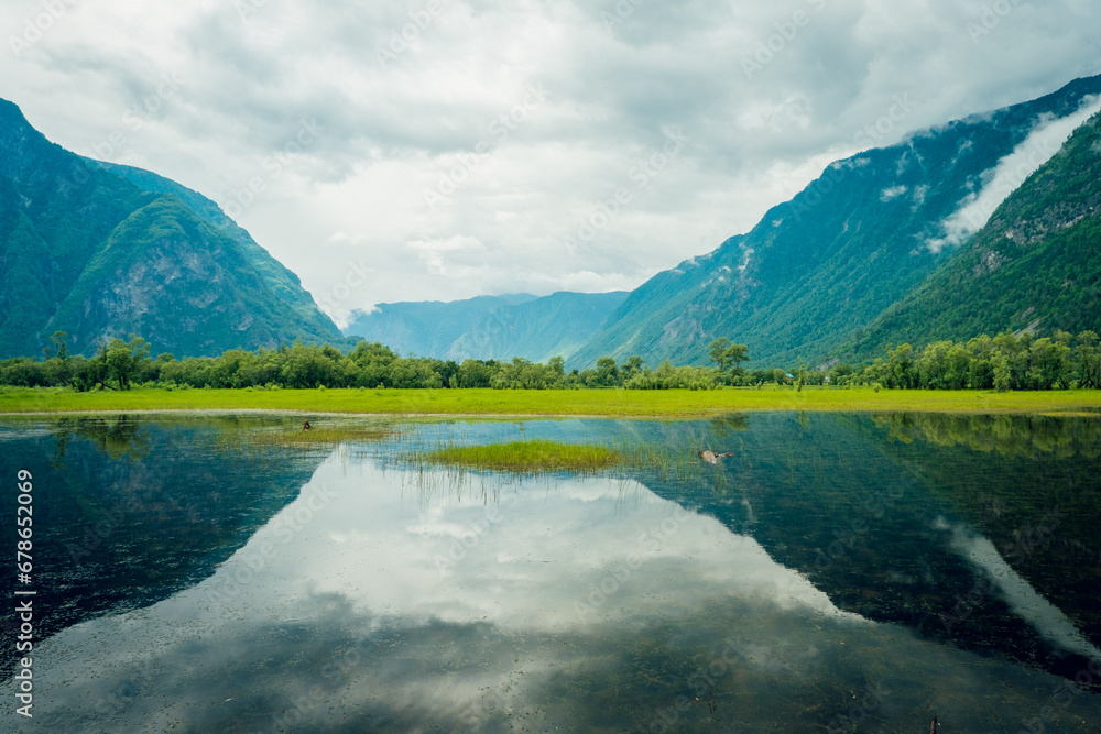 Cape Kyrsai on Lake Teletskoye in the Altai Mountains. Summer landscape in the mountains near a mountain lake Cape Kyrsai on Lake Teletskoye in the Altai Mountains. Summer landscape in the mountains near a mountain lake