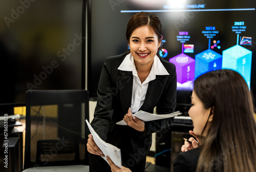 Smiling Asian working woman preparing documents in office photo