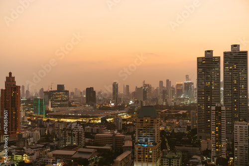 Wallpaper Mural A modern city skyline captured at sunset, with high-rise buildings illuminated by the golden glow of evening light. Torontodigital.ca