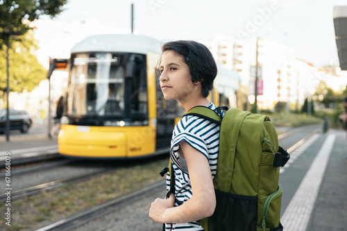 Canvas Print Teenage student girl waiting for the streetcar at the station  to go to school