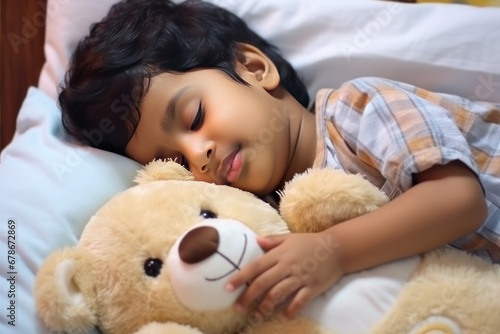 Toddler boy with dark hair in shirt sleeps sweetly in company of best friend teddy bear seeing pleasant dreams. Little boy has sweet dreams in bed with favorite toy small teddy bear