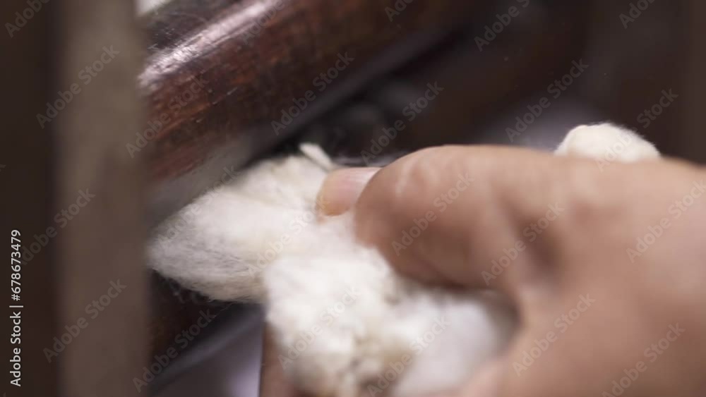 pressing brown cotton wool to remove seeds with wooden tool to prepare yarn, Thai local culture pressing brown cotton wool to remove seeds with wooden tool to prepare yarn, Thai local culture