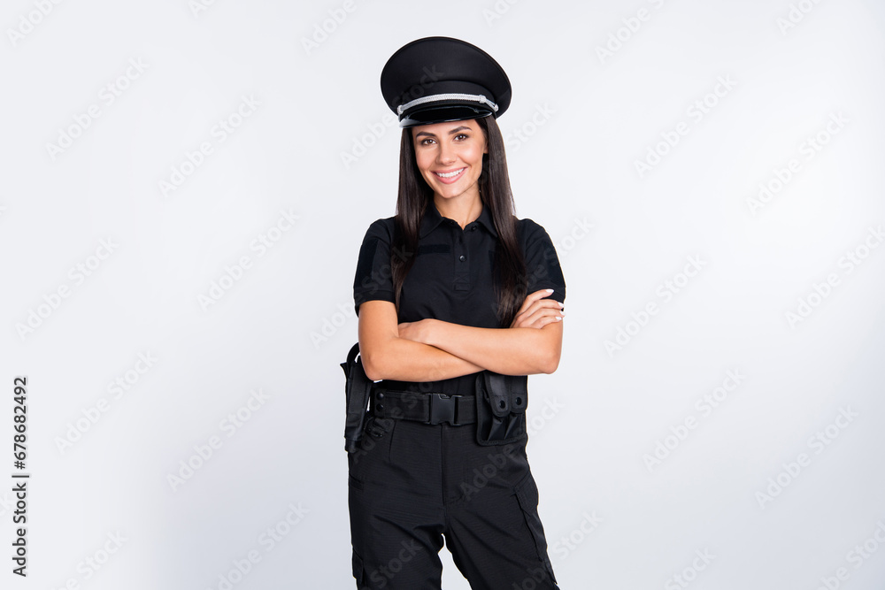 Photo of shiny confident young policewoman dressed black clothes headwear smiling arms crossed isolated white color background Photo of shiny confident young policewoman dressed black clothes headwear smiling arms crossed isolated white color background
