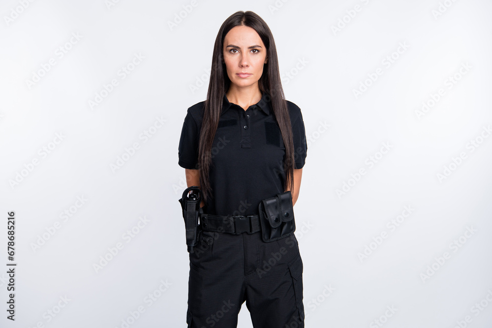 Photo of serious young professional police woman order force control isolated on grey color background Photo of serious young professional police woman order force control isolated on grey color background