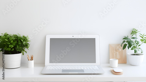 Modern Elegance, A Laptop Takes Center Stage on a White Table Surrounded by Greenery, Two Green Pots, and a Pencil Pot, and a Cup of Tea on white wall background generative AI © Laiba