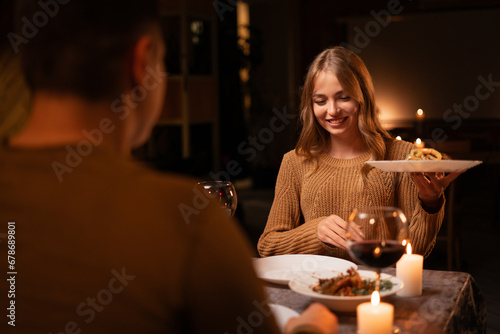 Handsome young man and beautiful woman while festive dinner at restaurant  St. Valentine s Day concept