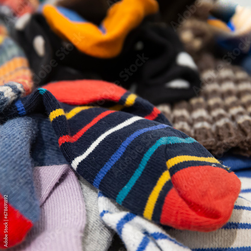 Pile of mismatched colored socks. Funny close-up picture of some messy kid socks. Square layout.