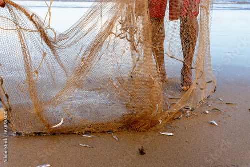 Fisherman is seen manipulating fishing net on the beach of Jaguaribe in the city of Salvador, Bahia. photo