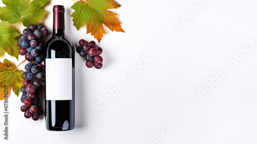 Bottle of red wine with ripe grapes and vine leaves on white background. Copy space, top view