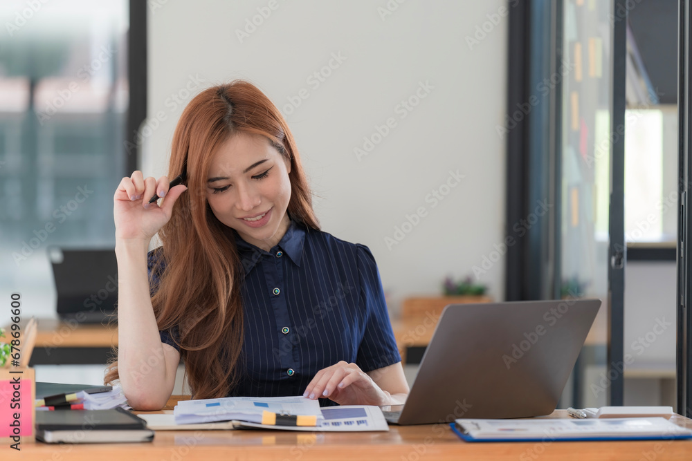 Asian woman working on a laptop computer, Working in the office with laptop concept, Young Asian woman starting a business using a laptop computer. Asian woman working on a laptop computer, Working in the office with laptop concept, Young Asian woman starting a business using a laptop computer.