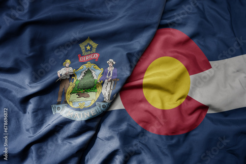 big waving colorful national flag of colorado state and flag of maine state . photo