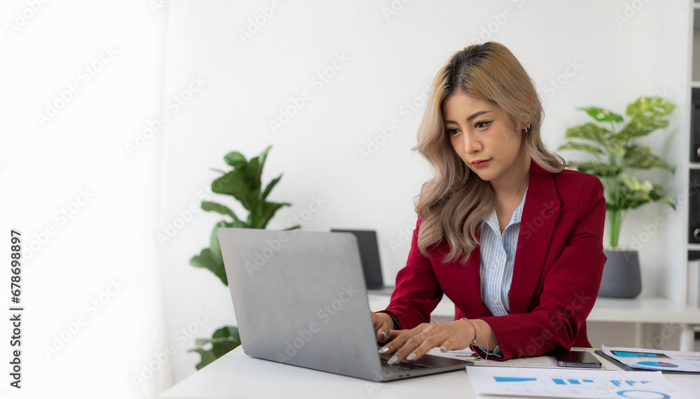 Young Asian woman working using laptop computer and financial documents in her workplace, freelancer, online marketing, telemarketing concept, e-commerce Young Asian woman working using laptop computer and financial documents in her workplace, freelancer, online marketing, telemarketing concept, e-commerce
