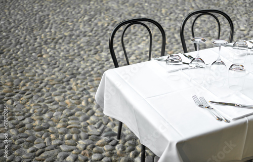 Elegant Restaurant table in terrace and rustic grey stone street background