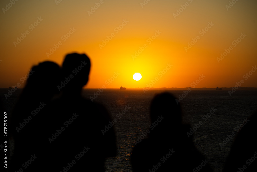 Silhouette of people enjoying the beautiful sunset.