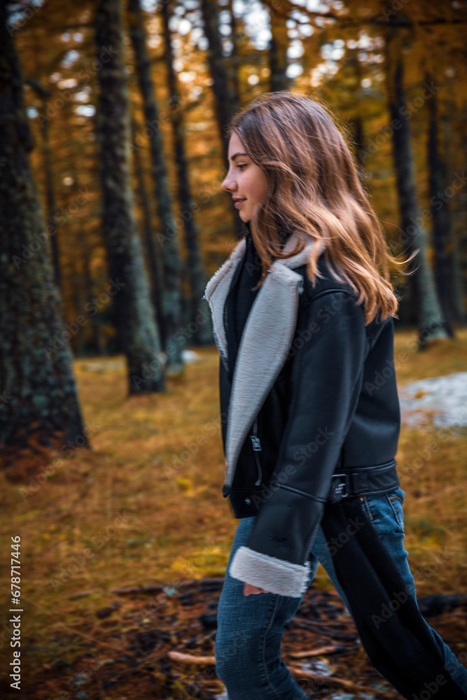 Portrait of young teenage girl walking through forest with autumn colors of yellow and orange. Meran, South Tirol, Italy Portrait of young teenage girl walking through forest with autumn colors of yellow and orange. Meran, South Tirol, Italy