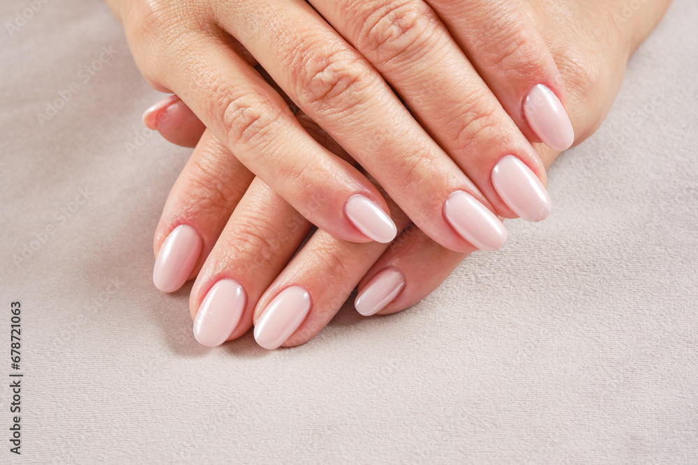 Hands with French manicure. New Perfect artificial fingernails of adult woman. Care for sensuality female hands. Shallow depth of field
