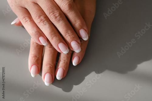 Hands with French manicure. New Perfect fingernails of woman.  Care for sensuality female hands. Shallow depth of field. Top view