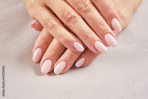 Hands with French manicure. New Perfect artificial fingernails of adult woman. Care for sensuality female hands. Shallow depth of field