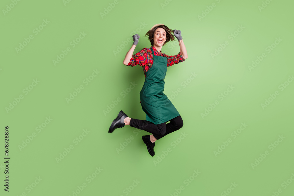 Full body profile portrait of astonished lady fists up open mouth shout yes isolated on green color background Full body profile portrait of astonished lady fists up open mouth shout yes isolated on green color background
