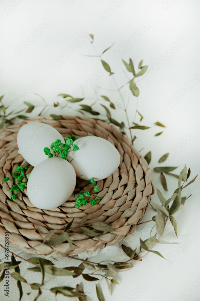 Easter white and brown eggs in a basket with flowers on a white background Easter white and brown eggs in a basket with flowers on a white background