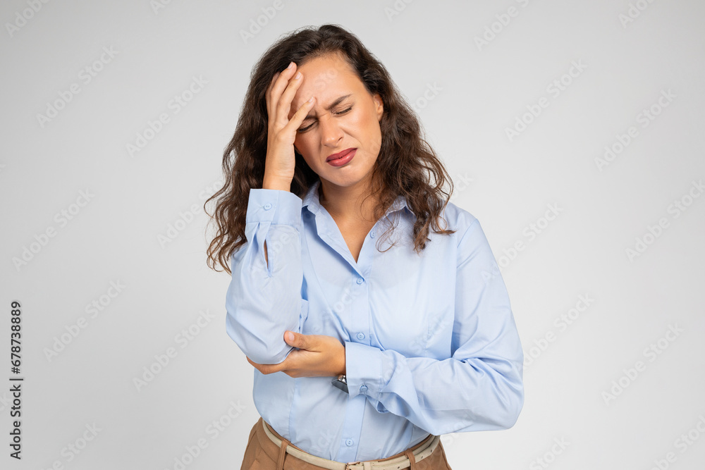 Upset millennial caucasian lady, with pained expression, clutching forehead, suffer from headache Upset millennial caucasian lady, with pained expression, clutching forehead, suffer from headache
