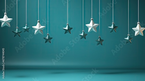  a group of white and silver stars hanging from a string on a teal green wall with a shadow on the floor and a shadow on the floor below them.