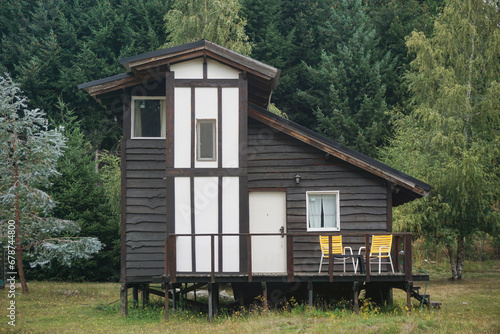 Old wooden house in the middle of a meadow in the forest