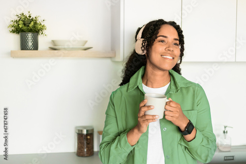 Happy African American Lady Wearing Headphones Holding Coffee Cup Indoor