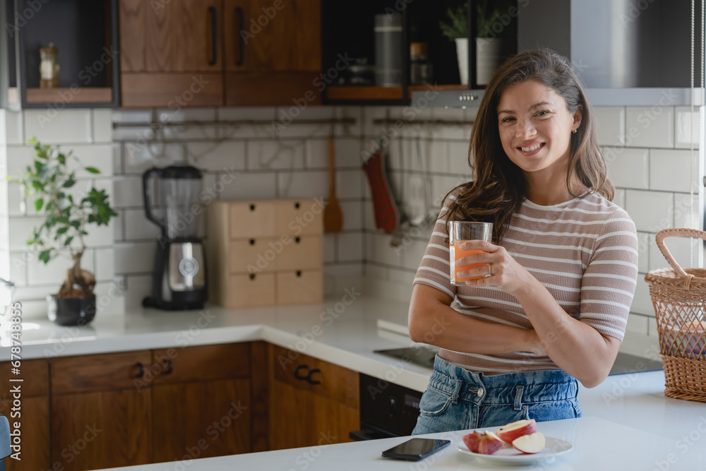 Portrait of beautiful young smiling woman standing in the morning in home kitchen before having her healthy fruit breakfast Portrait of beautiful young smiling woman standing in the morning in home kitchen before having her healthy fruit breakfast