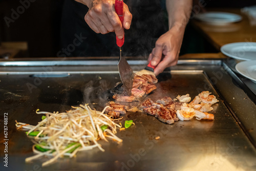 Chef cooking in Japanese teppanyaki restaurant photo