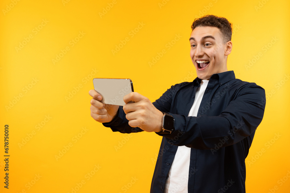 Happy guy holding smartphone in his hands and smiling Happy guy holding smartphone in his hands and smiling