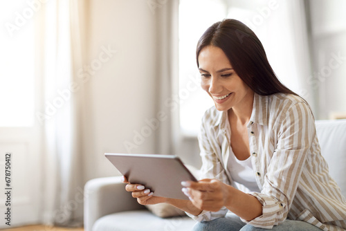 Modern Technologies. Smiling Young Female Using Digital Tablet At Home