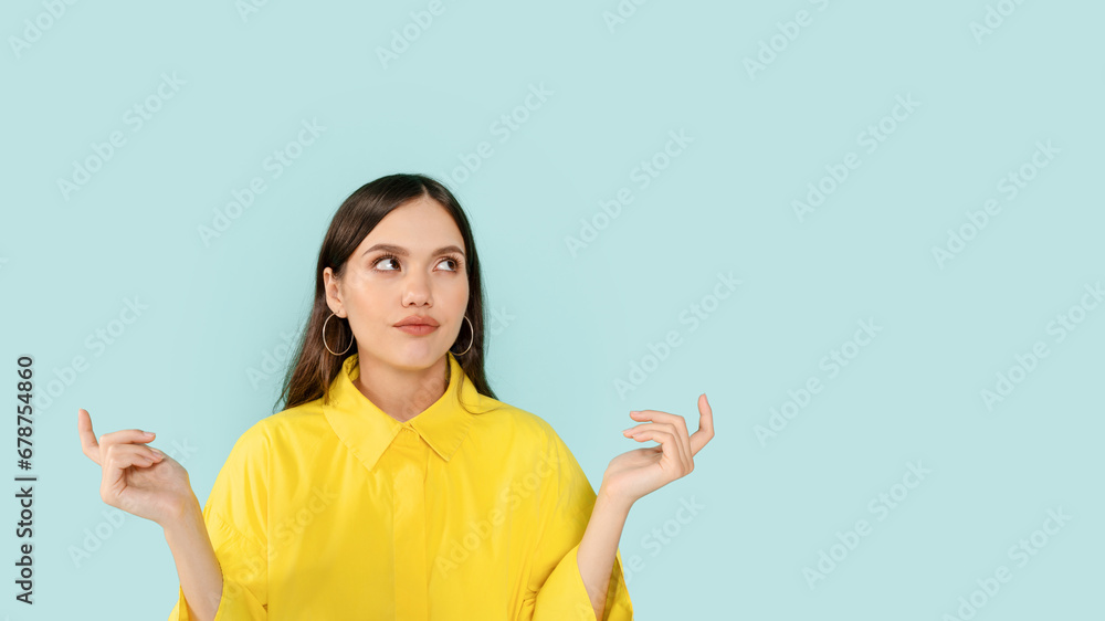 Confused young lady looking at copy space and gesturing Confused young lady looking at copy space and gesturing