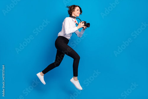 Full length photo of cheerful paparazzi girl hurry fast look empty space isolated on blue color background