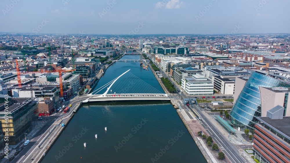 Naklejka premium Aerial shot of cityscape of Dublin and the Samuel Beckett Bridge,a cable-stayed swingbridge,Ireland