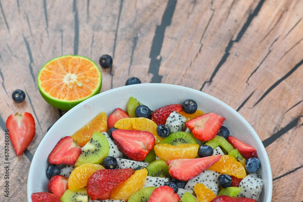 Fresh fruit salad bowl on wood grain table concept healthy food, to control weight, to lose weight