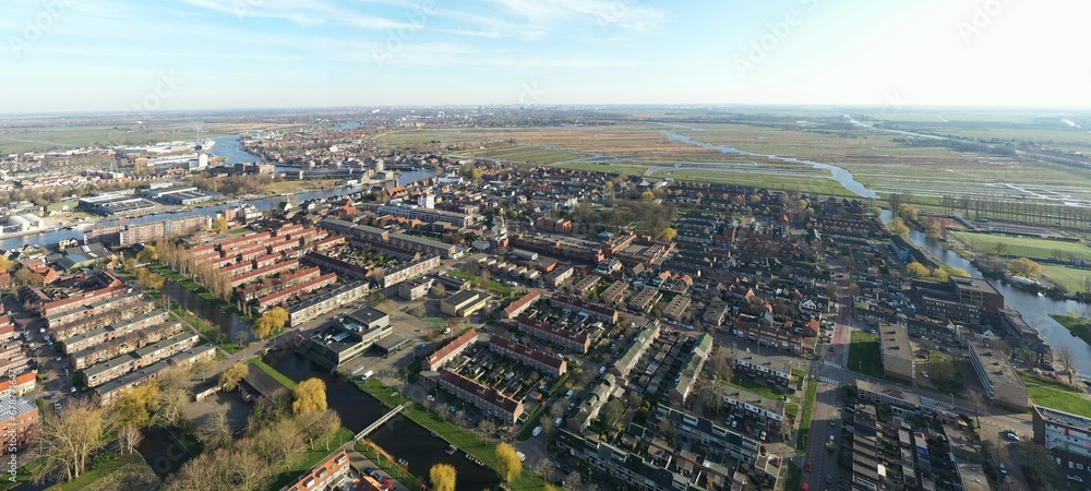 Aerial shot of a city with small buildings and fields