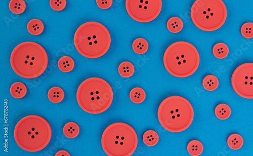 Coral buttons of different sizes on a background of blue fabric