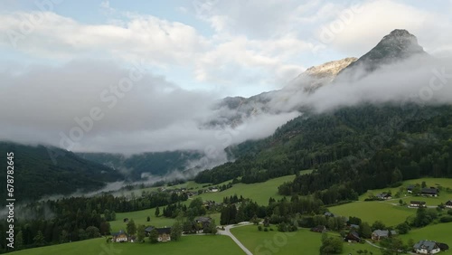 View of Austrian Alps landscape, mountain peak Sarstein in the morning mist and clouds. The meadow in foreground. photo