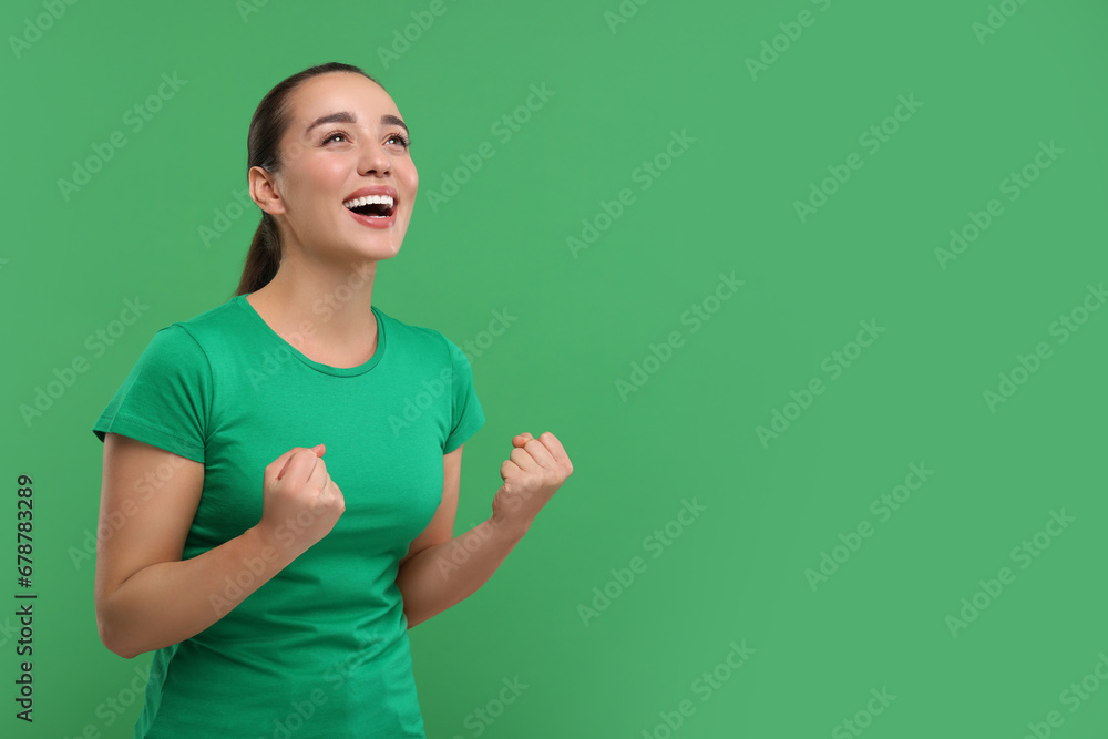 Happy sports fan celebrating on green background, space for text Happy sports fan celebrating on green background, space for text
