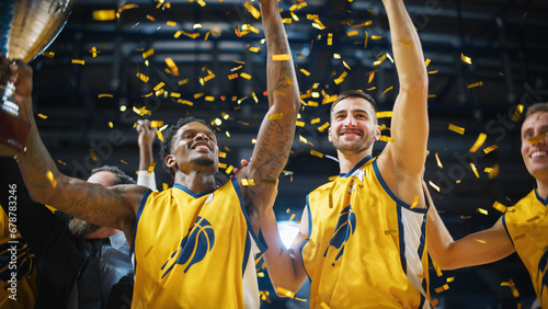 Multiethnic Basketball Players Celebrate Championship Victory with Hugs, Jumping, Holding the Trophy High. Exclusive Joyful Sports Action on Live TV and Pay Per View Internet Streaming Concept. photo