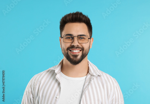 Handsome man wearing glasses on turquoise background © New Africa