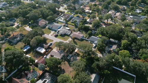 A Florida subdivision consisting of single family houses is shown from an aerial flyover view during the day.