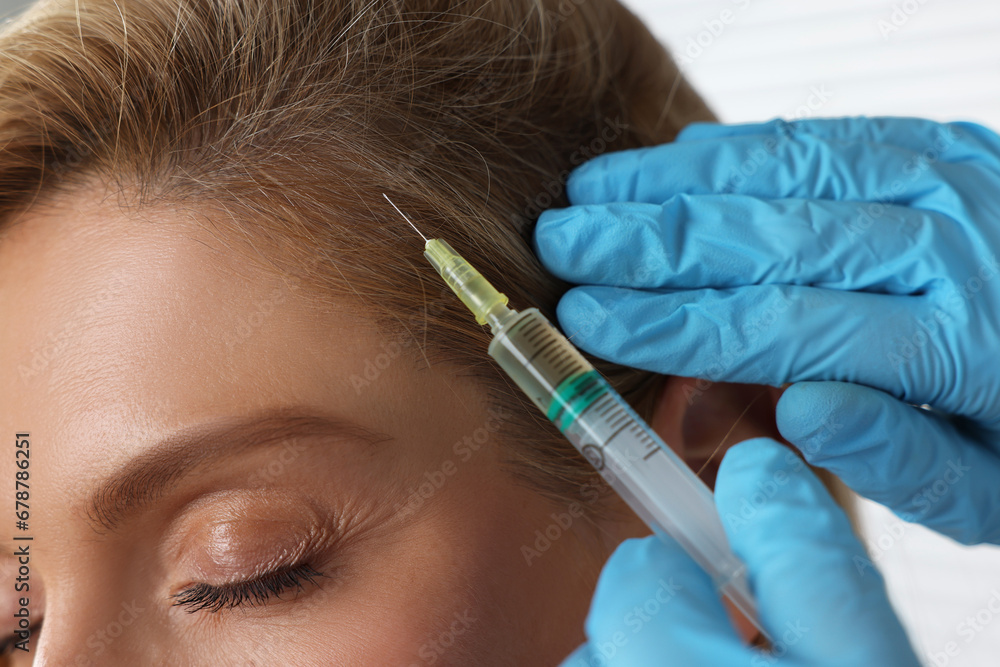 Trichologist giving injection to patient in clinic, closeup Trichologist giving injection to patient in clinic, closeup