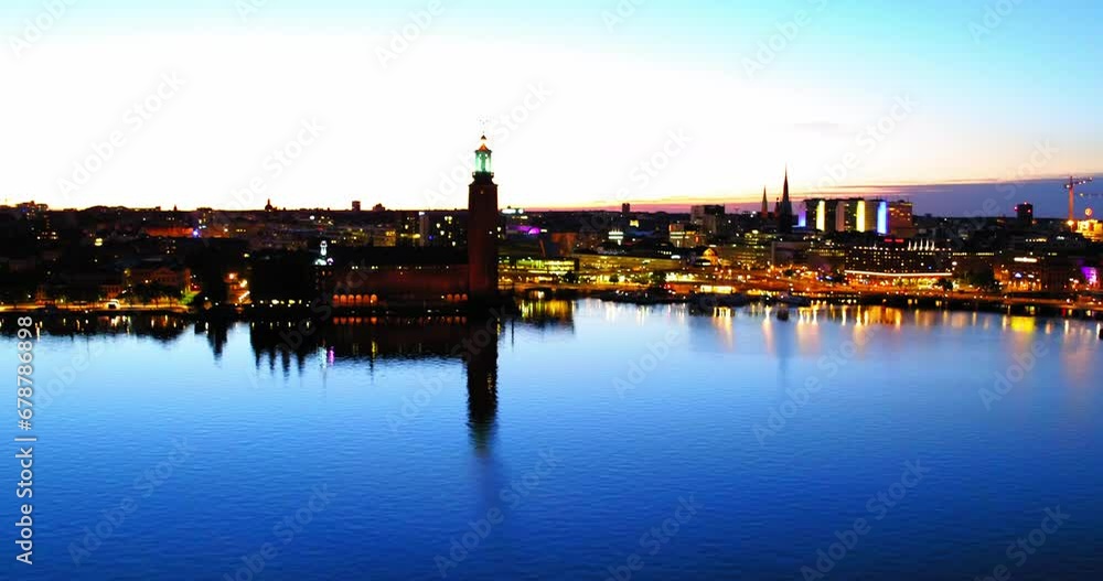 Aerial: Drone Panning Shot Of Illuminated Buildings Near Blue Sea In City Against Sky - Stockholm, Sweden Aerial: Drone Panning Shot Of Illuminated Buildings Near Blue Sea In City Against Sky - Stockholm, Sweden