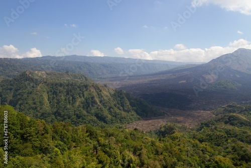 Scenic view of the rocky mountains covered with green plants and trees on a sunny day