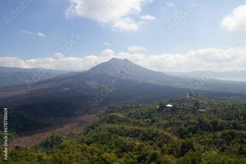 Scenic view of the rocky mountains covered with green plants and trees on a sunny day