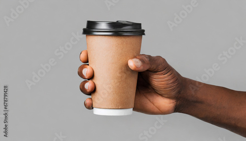 mockup of male hand holding a coffee paper cup isolated on light grey background photo