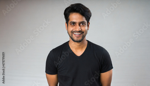 people positive emotions concept studio waist up of young happy smiling broadly hindu man standing in centre isolated on white background wearing black casual t shirt looking straight at camera photo
